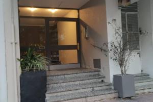 una puerta delantera de un edificio con escaleras y macetas en Apto Centrico Zona Tres Cruces, en Montevideo