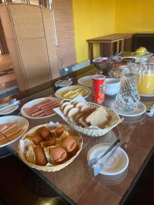 einen Tisch mit Körben mit Brot und anderen Lebensmitteln in der Unterkunft Villa Rural in Campos do Jordão