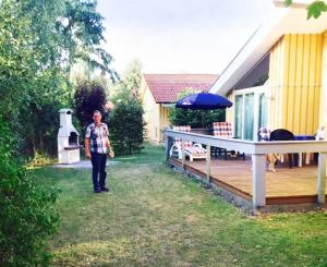 a man standing in a yard next to a house at Seeschwalbe 11 in Mirow +3 photos
