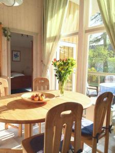 a wooden table with a bowl of fruit and flowers on it at Seeschwalbe 11 in Mirow