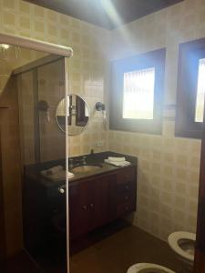a bathroom with a sink and a shower with a mirror at Villa Rural in Campos do Jordão