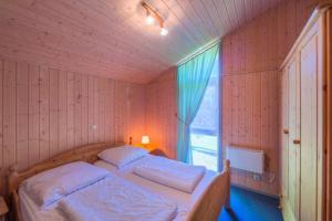 1 dormitorio con 1 cama en una habitación con ventana en Seeschwalbe 32, en Mirow