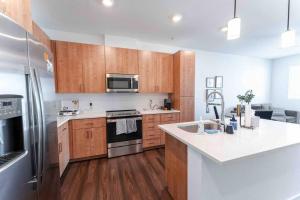 a kitchen with wooden cabinets and a stainless steel refrigerator at Gateway to Old Town Scottsdale King 1 BR & Balcony in Scottsdale
