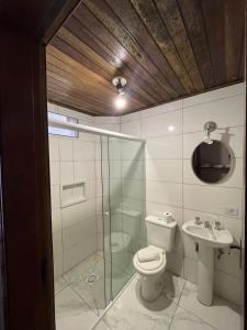 a bathroom with a shower and a toilet and a sink at Villa Rural in Campos do Jordão