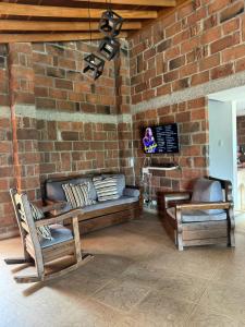 a room with a brick wall with a couch and a chair at FINCA VILLA LORA GIRARDOTA in Girardota