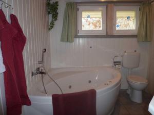 ein Badezimmer mit einer weißen Badewanne und einem WC in der Unterkunft Seeschwalbe 198 in Mirow