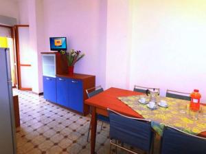 uma sala de jantar com uma mesa e cadeiras azuis em Bright and cosy apartment - Beahost Rentals em Bibione