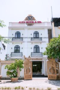 ALEX HOTEL AND SPA في An Bàn: مبنى ابيض امامه بوابة