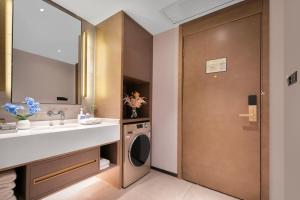 a bathroom with a sink and a washing machine at Changsha Zealandia Serviced Apartment in Changsha