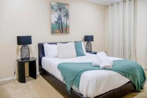 a bedroom with a bed with two lamps on it at 6 Bedroom Beach & Lake Oasis in The Entrance