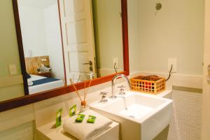 Palace Beach Hostel في ريو دي جانيرو: حمام مع حوض ومرآة