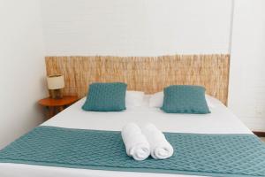 uma cama com duas almofadas e toalhas em Palace Beach Hostel no Rio de Janeiro