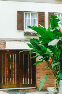 リオデジャネイロにあるPalace Beach Hostelの木の扉と植物のある家
