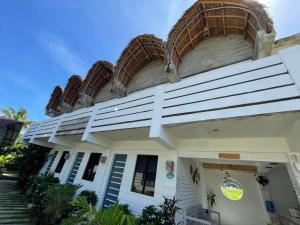 a white building with baskets on top of it at Point F Siargao in Catangnan