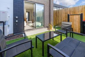 a small garden with two chairs and a table at Stadium Suite - CBD in Christchurch