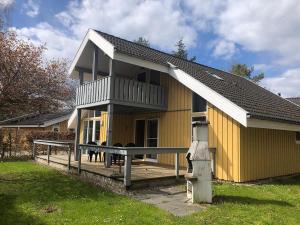 a yellow house with a porch and a balcony at Seeschwalbe Classic 226 in Mirow