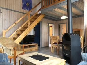 a living room with a wood stove and a staircase at Seeschwalbe Classic 226 in Mirow