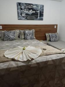 Una cama grande con un vestido encima. en Pousada Maceió é Massa Praia de Pajuçara, en Maceió