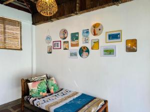 1 dormitorio con 1 cama y cuadros en la pared en Balai Roco, en Bauang