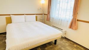 a large bed in a room with a window at Toyoko Inn Sakudaira-eki Asama-guchi in Saku