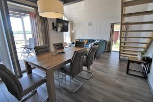 ein Wohnzimmer mit einem Holztisch und Stühlen in der Unterkunft Seeschwalbe Classic 309 in Mirow