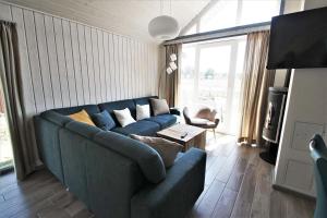 a living room with a blue couch and a large window at Seeschwalbe Classic 310 in Mirow