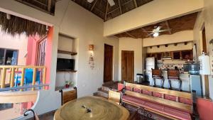 a room with a wooden table and benches and a kitchen at Villas Chulavista in Sayulita