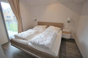 un grande letto in una stanza con finestra di Seeschwalbe Classic 314 a Mirow