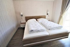 a bed with white sheets and pillows in a room at Seeschwalbe Classic 318 in Mirow