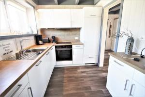 a kitchen with white cabinets and a sink and a stove at Seeschwalbe Classic 318 in Mirow