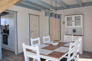 a dining room with a table and white chairs at Seeschwalbe Classic 319 in Mirow