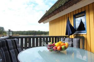 a bowl of fruit on a glass table on a balcony at Bootshaus 600 in Mirow
