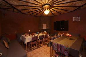 マラケシュにあるLocanda Lodge, Marrakech Tacheddirtの大きな天井のダイニングルーム(テーブル、椅子付)