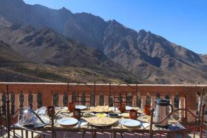 ein Tisch mit Essen drauf mit Bergen im Hintergrund in der Unterkunft Locanda Lodge, Marrakech Tacheddirt in Marrakesch