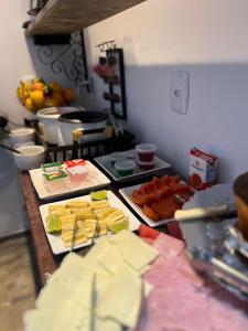 Pousada Cristais SUITE 15 في تيوفيلو أوتوني: مطبخ مع الجبن وغيرها من الأطعمة على الطاولة