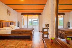 Un dormitorio con una cama y una ventana grande. en Savieza Life Experience, en Nemocón