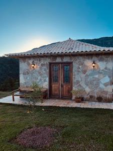 a stone house with a wooden door on a patio at Refúgio São José in Tiradentes