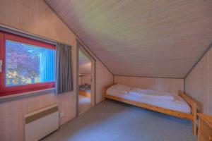 Una pequeña habitación con una cama y una ventana. en Wildgans 48, en Mirow