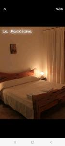 a bedroom with a large bed with a white curtain at La Macciona in Aglientu