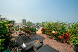 a balcony with tables and chairs and a view of a city at The Light Hotel in Hanoi