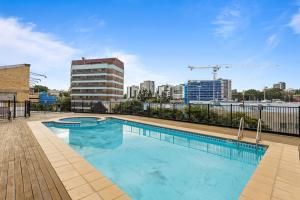 a swimming pool with a city skyline in the background at Stylish Riverside 1Bed/Studio with Rooftop Pool in Brisbane