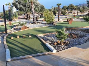 um campo de mini-golfe num parque com palmeiras em Mobil-Home Caves, 3 pièces, 4 personnes - FR-1-783-32 em Caves