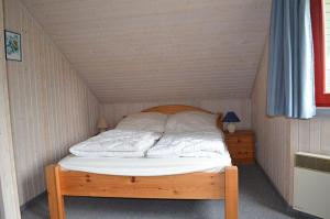 uma cama num quarto com uma cama de madeira em Wildgans 80 em Mirow