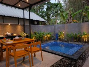 a patio with a table and a swimming pool at Niti Bhumi Villa in Borobudur
