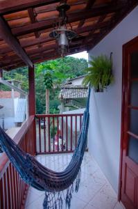 a porch with a hammock on a balcony at Pouso Trindade in Trindade