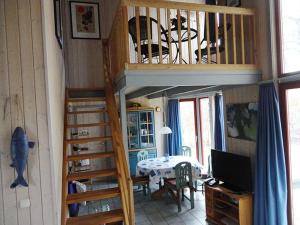um quarto com uma escada em espiral e uma sala de jantar em Wildgans 114 em Mirow