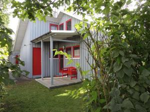 uma casa branca com portas vermelhas e janelas vermelhas em Wildgans 114 em Mirow