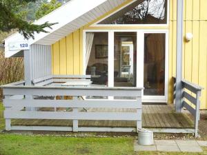 a front porch of a house with a white fence at Wildgans 128 in Mirow