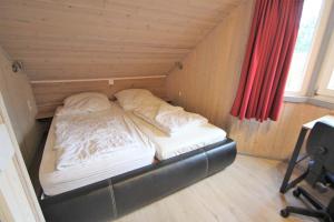 a small bed in a room with a window at Wildgans 128 in Mirow