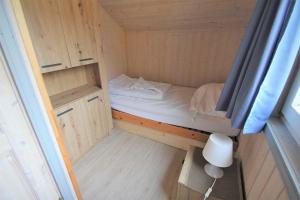 a small room with a bed and a window at Wildgans 128 in Mirow +4 photos